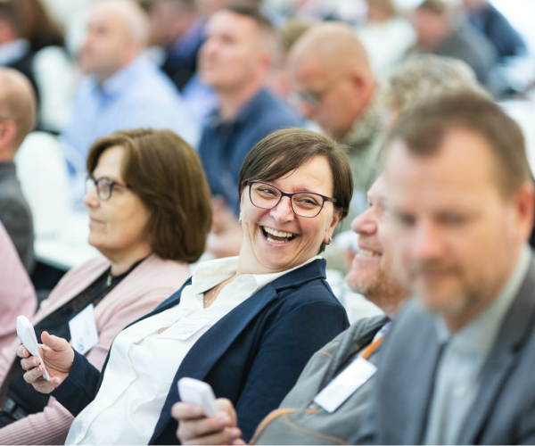 Woman smiling in audience at business conference